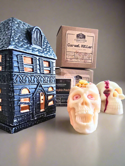 Haunted Essentials: Skulls and Pumpkins Bundle featuring a haunted house fragrance warmer, two skull-shaped soy wax candles, and pumpkin patch soy wax melts. Perfect for Halloween decor with spooky, seasonal scents. www.farmhousecharmcandles.com