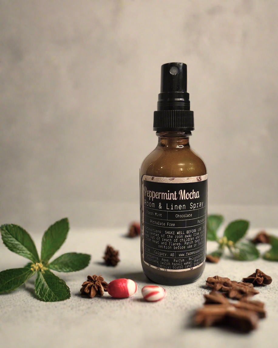 A 2 oz bottle of Peppermint Mocha Room & Linen Spray with a festive blend of coffee, chocolate, and peppermint.
Peppermint Mocha Room & Linen Spray perfect for creating a cozy holiday atmosphere.
Peppermint Mocha Room & Linen Spray bottle placed on a winter-themed background with holiday decorations.